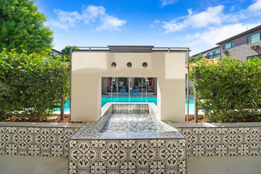 a pool with a fountain in the middle of a house