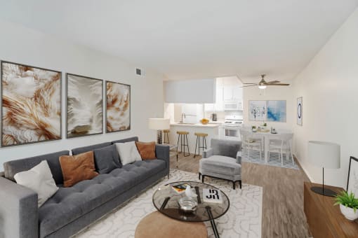 a living room with a couch and a coffee table and a kitchen with a table
