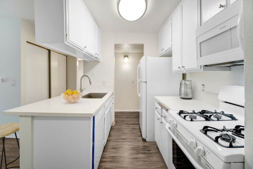 a white kitchen with white appliances and a white counter top