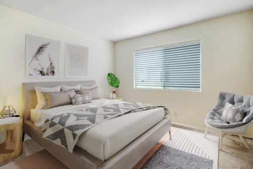 a bedroom with a bed and a chair and a window