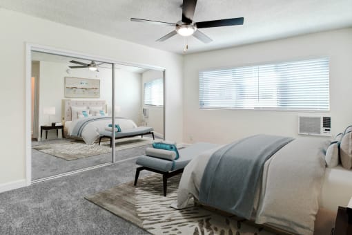 a bedroom with a large mirror and a ceiling fan