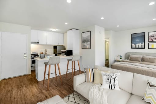 a living room with a couch and a kitchen and a bed