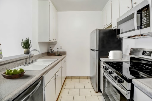 an all white kitchen with stainless steel appliances and a sink