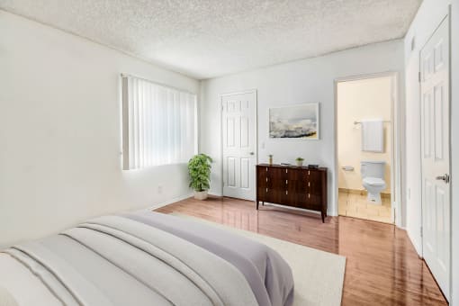 a bedroom with a bed and a bathroom with a toilet
