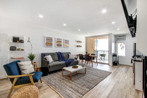 Furnished 1 Bedroom Suite, living room with cozy fireplace, wood inspired floors throughout unit