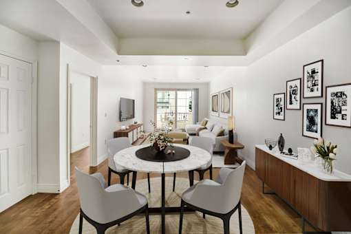 a living room with a round table and white chairs