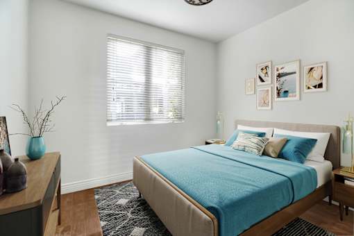 a bedroom with a bed and a desk and a window