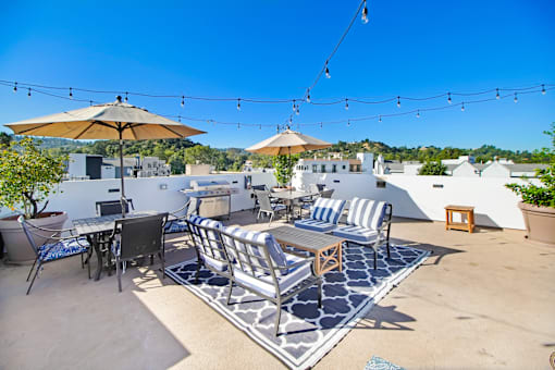 a patio with tables and chairs and umbrellas on a roof