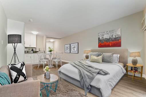 Sleeping and living area of a studio unit with a dining and kitchen area on the left