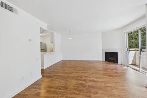 A large empty room with wooden floors and white walls.