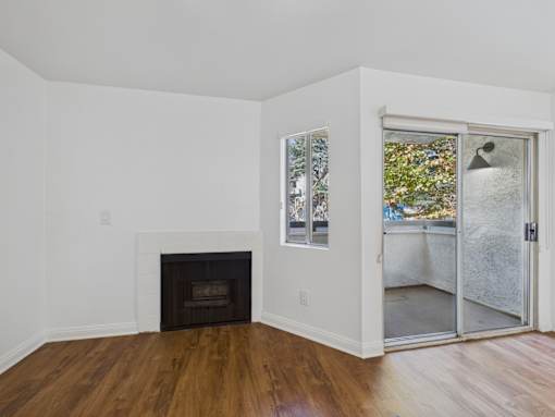A room with a fireplace and a sliding glass door.