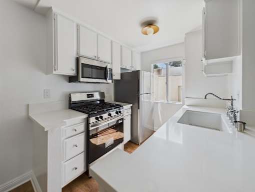 A white kitchen with a black stove and a black refrigerator.