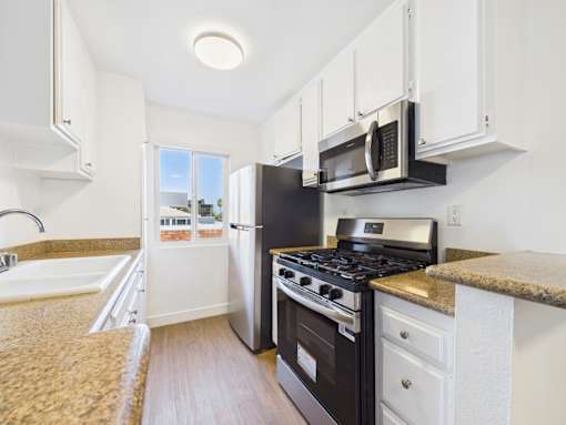 A kitchen with a black stove and white cabinets.