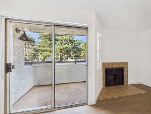 A room with a fireplace and sliding glass doors.