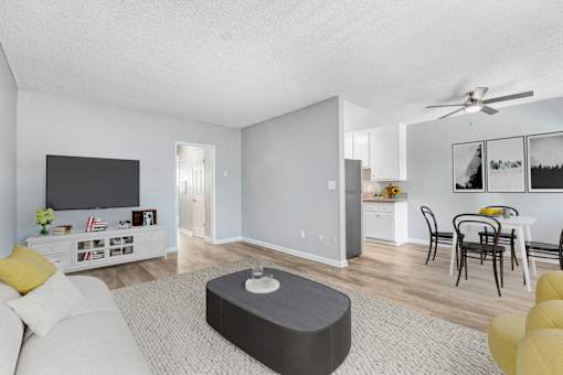 A living room with a white couch and a grey ottoman.