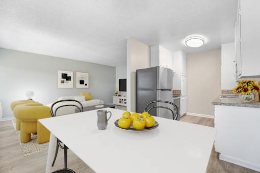 A kitchen with a table and chairs and a bowl of lemons on the table.