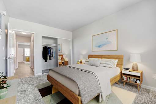 A bedroom with a large bed and a painting on the wall.