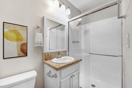 A bathroom with a white tub, sink, and shower.