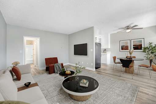 A modern living room with a black coffee table in the center.