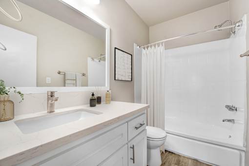 A white bathroom with a sink, toilet, and bathtub.