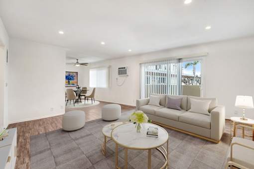 A living room with a white couch, a coffee table, and a painting on the wall.