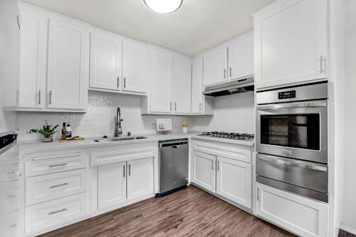 A kitchen with white cabinets and stainless steel appliances.
