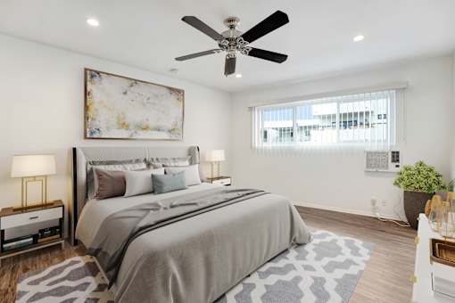 A bedroom with a large bed and a ceiling fan.