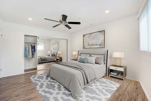 A bedroom with a large bed and a ceiling fan.