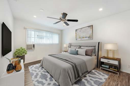 A bedroom with a large bed and a ceiling fan.