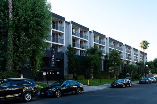 an apartment building with cars parked in front of it