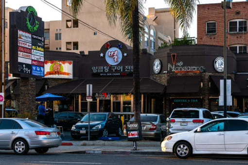 a city street with cars parked in front of a restaurant