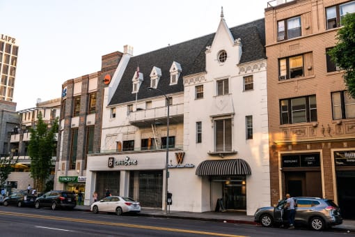 a white building with a black roof on a city street
