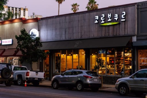 a city street with cars parked in front of a store
