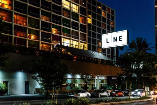 a large white sign that says line in front of a tall building