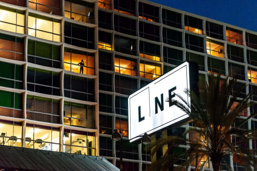 a man stands on a ledge in front of a building with a sign that says ln