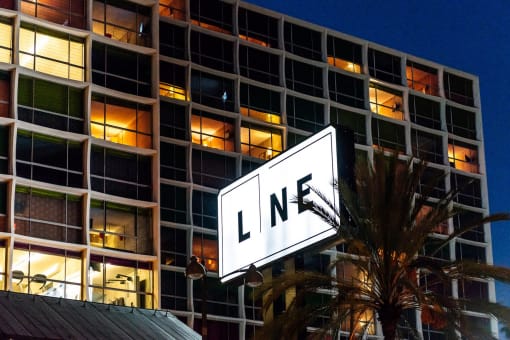 a large white sign with the word line on it in front of a large building at night