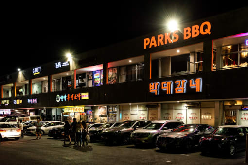 a parking lot in front of a store at night