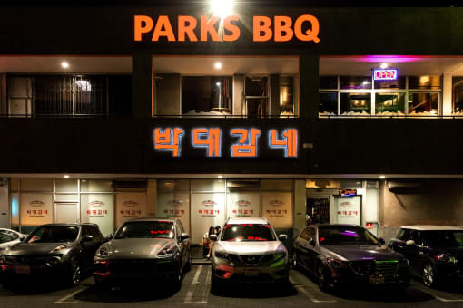 a parking lot in front of a building with a sign that reads parks bbq
