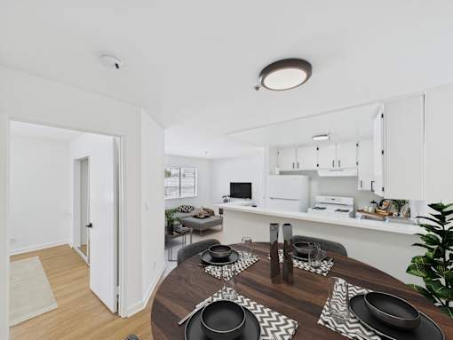 A modern dining room with a wooden table set for a meal.