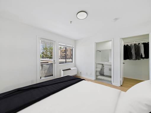 A white room with a black mattress and a window.