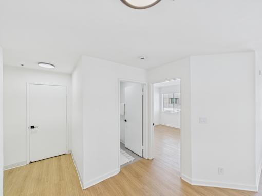 A white room with a door and a window.