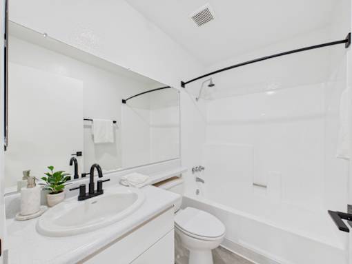 A white bathroom with a toilet, sink, and bathtub.