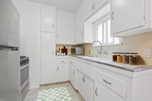 a white kitchen with a sink and a window