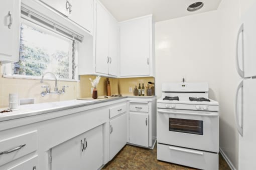 a white kitchen with white appliances and white cabinets