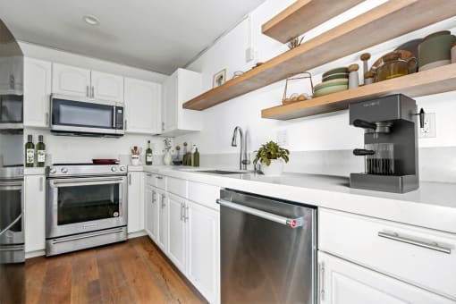 a kitchen with white cabinets and stainless steel appliances