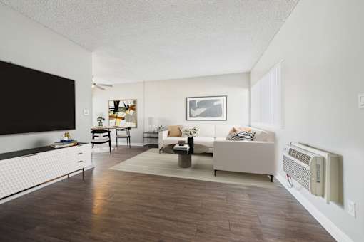 A living room with a white couch and a wooden floor.