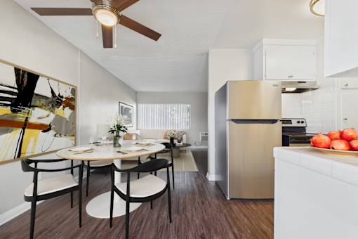 A modern kitchen with a dining table set for two.