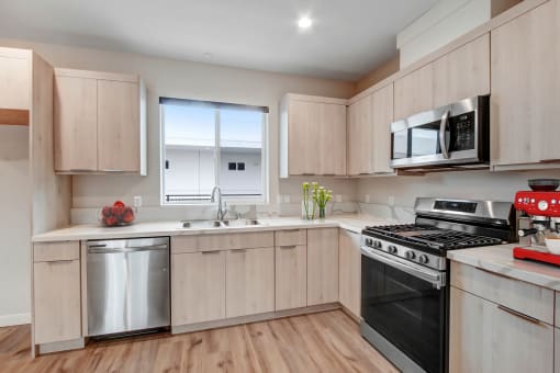 a kitchen with light wood cabinets and stainless steel appliances