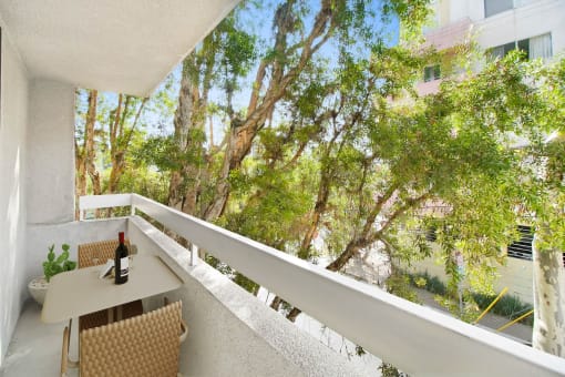 a balcony with a table and a bottle of wine on it