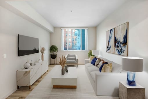 a living room with white furniture and a large window